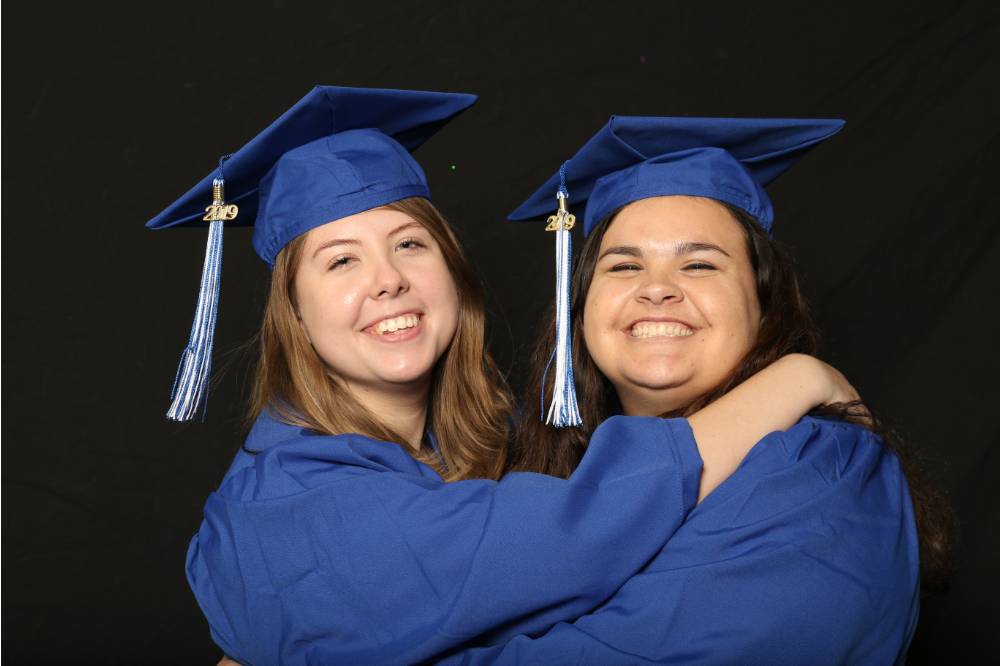 two soon to be graduates hugging for a picture